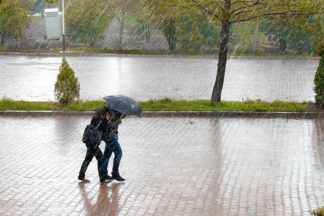 大雨の中二人で傘をさす人