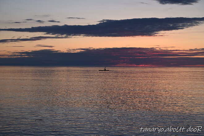 知床の海の夕暮れに一台のボートと人