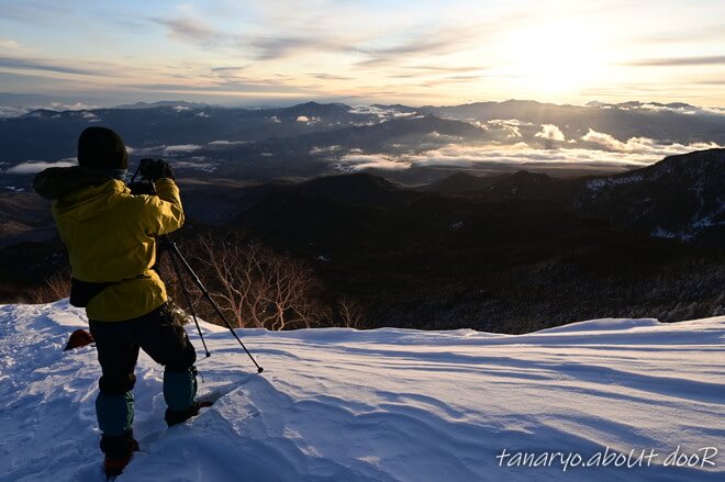 厳冬期の山で写真を撮る登山者