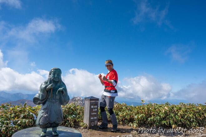 越後駒ケ岳の山頂でポーズを撮る男性